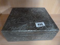 A pewter box decorated with flowers