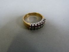 An 18ct gold ring with two bands of ruby's and emeralds- size J, total weight 3.6g