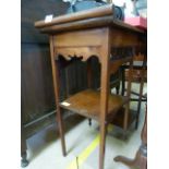 An Edwardian mahogany occasional table decorated with fretwork and two tier undershelves