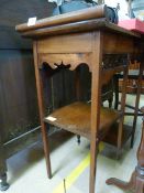 An Edwardian mahogany occasional table decorated with fretwork and two tier undershelves