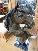 A modern bronze of a horses head with a foal