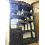 A Chinese carved hardwood side cabinet decorated throughout with carved and pierced scrolling and