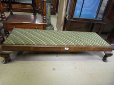 A long low upholstered mahogany footstool