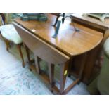 An oak drop leaf table on square tapering legs