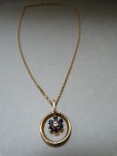 An 18ct gold pendant set with single Diamond and six Sapphires on an 18ct gold chain