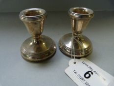 A pair of hallmarked silver stubby candlesticks