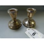 A pair of hallmarked silver stubby candlesticks