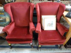 A pair of red fireside chairs on cabriole legs
