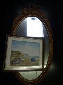 A gilt framed oval mirror and a watercolour of a beach scene