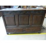 A large oak coffer with carved decoration to front