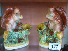 A pair of Staffordshire spill vases in the form of squirrels