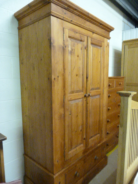 A pine double wardrobe with drawer under