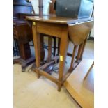 An oak drop leaf table on square tapering legs