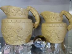 Two hunting jugs with raised decoration, the handles formed of dogs, along with a Caithness "moon