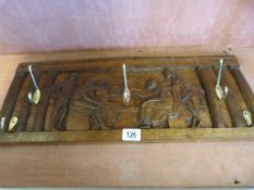 A carved oak panel with a classical scene converted to a coat rack
