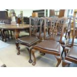 A Mahogany oval extending table with extra leaf and six matching chairs on claw and ball feet -
