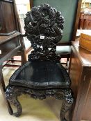 A heavily carved Chinese hall chair decorated with dragons