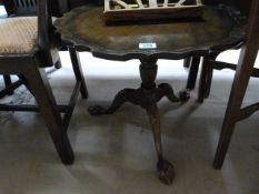 An oak pie crust table on carved claw and ball feet