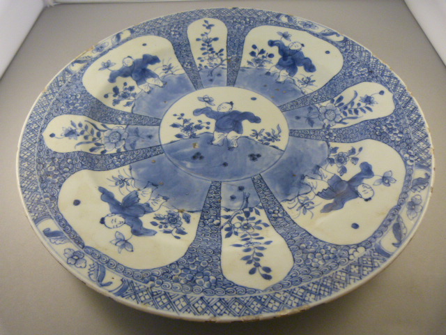 A Japanese blue and white charger with seal mark to base- hairline crack and nibbles to rim