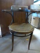 An oak captain style chair with hammered decoration to seat