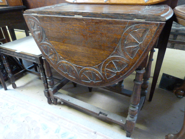 An oak dropleaf table with carved decoration