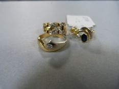 Three gold coloured rings each with inset stones.