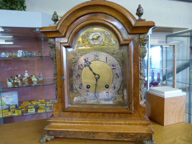 A walnut veneered bracket clock with brass and silvered dial- 1 finial replaced- pendulum and key in