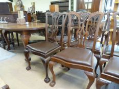 A Mahogany oval extending table with extra leaf and six matching chairs on claw and ball feet -