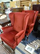 A pair of red fireside chairs on cabriole legs