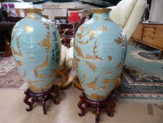 A pair of large Oriental vases on stands approx 3ft tall, with gold leaf decoration and dragons