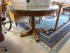 An oak round pedestal dining room table