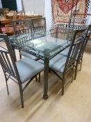 A glass topped dining table with wrought iron base and six chairs