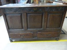 A large oak coffer with carved decoration to front