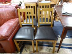A set of four leather seated dining room chairs