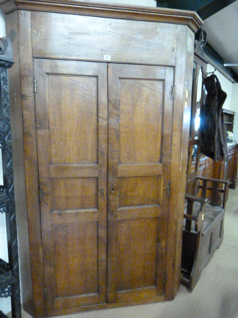A Georgian oak panelled corner cupboard