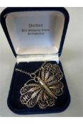 A silver metal necklace with Butterfly Filigree pendant