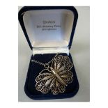 A silver metal necklace with Butterfly Filigree pendant