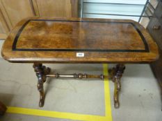 A walnut coffee table with turned wooden stretcher with carved wooden feet.