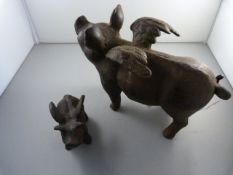 A Cast iron flying pig and another matching miniature version