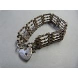 A Hallmarked silver gated bracelet joined together by a Padlock heart and safety chain 16 g