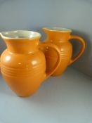 A pair of Le Creuset orange pottery jugs