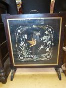 An oak framed fire screen with silk work panel embroidered with birds butterflies and flowers