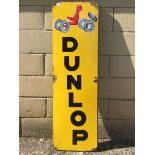 A French Dunlop part pictorial enamel sign depicting a figure poised to drive a car, 12 x 38 1/2".