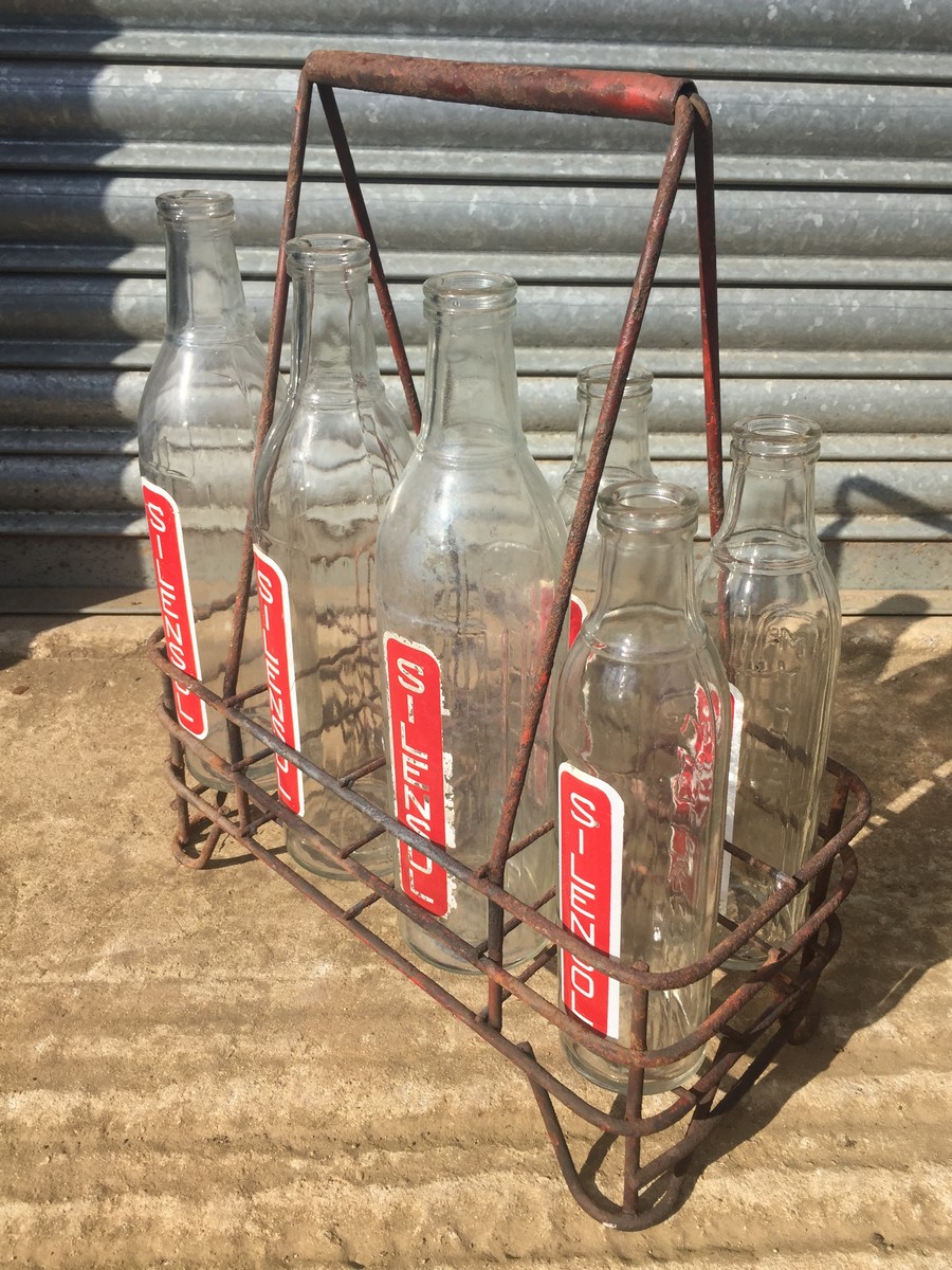 An oil bottle crate containing three large Silensol oil bottles and three smaller, all with original