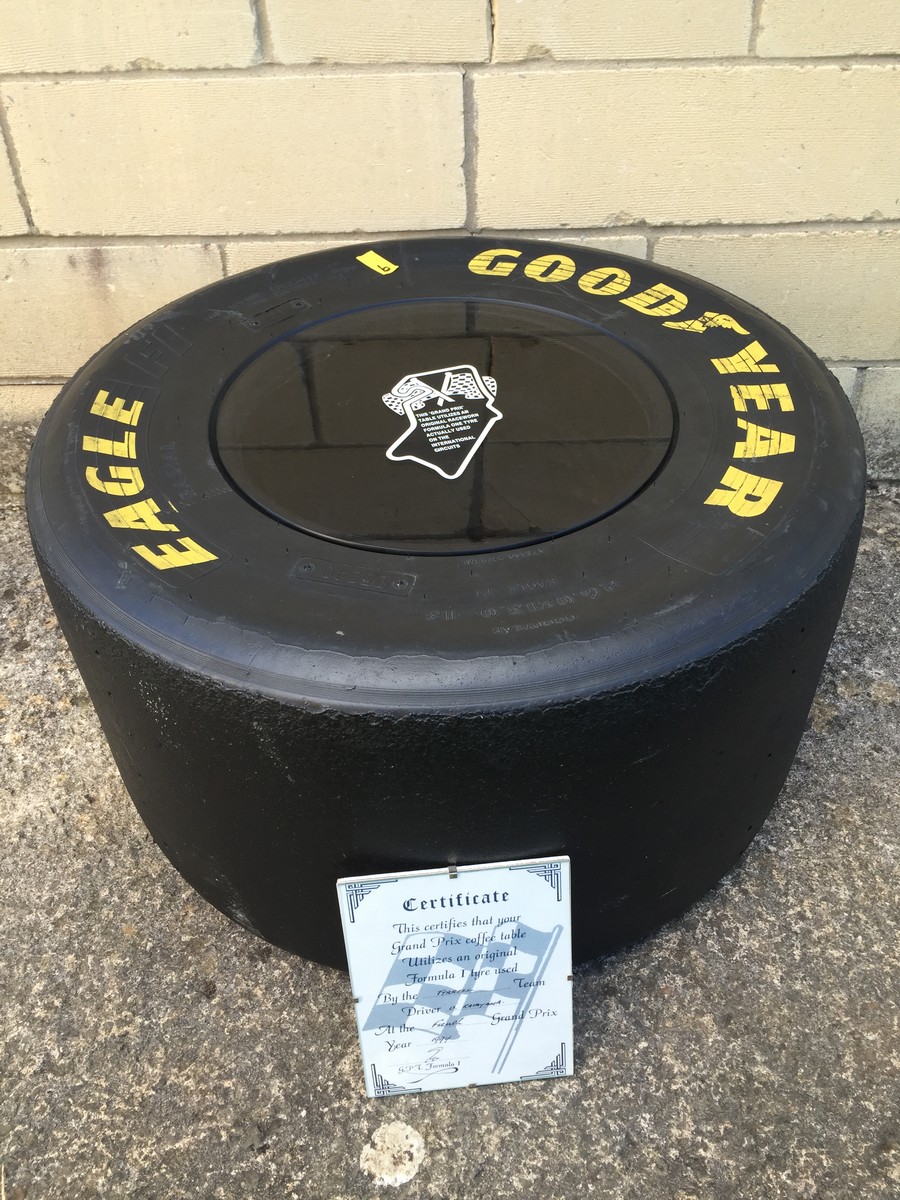 A Tyrrell Formula 1 tyre, forming a table with a glass top and certificate.