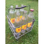A nine-sectioned galvanised oil bottle crate containing six Shell Rotella Oil quart bottles, one