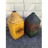 A Staminol five gallon pyramid can and an Agricastrol Tractor Oil five gallon pyramid can.