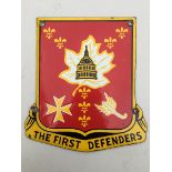 A small enamel sign - 'The First Defenders', in the shape of a coat of arms, enamel in very good