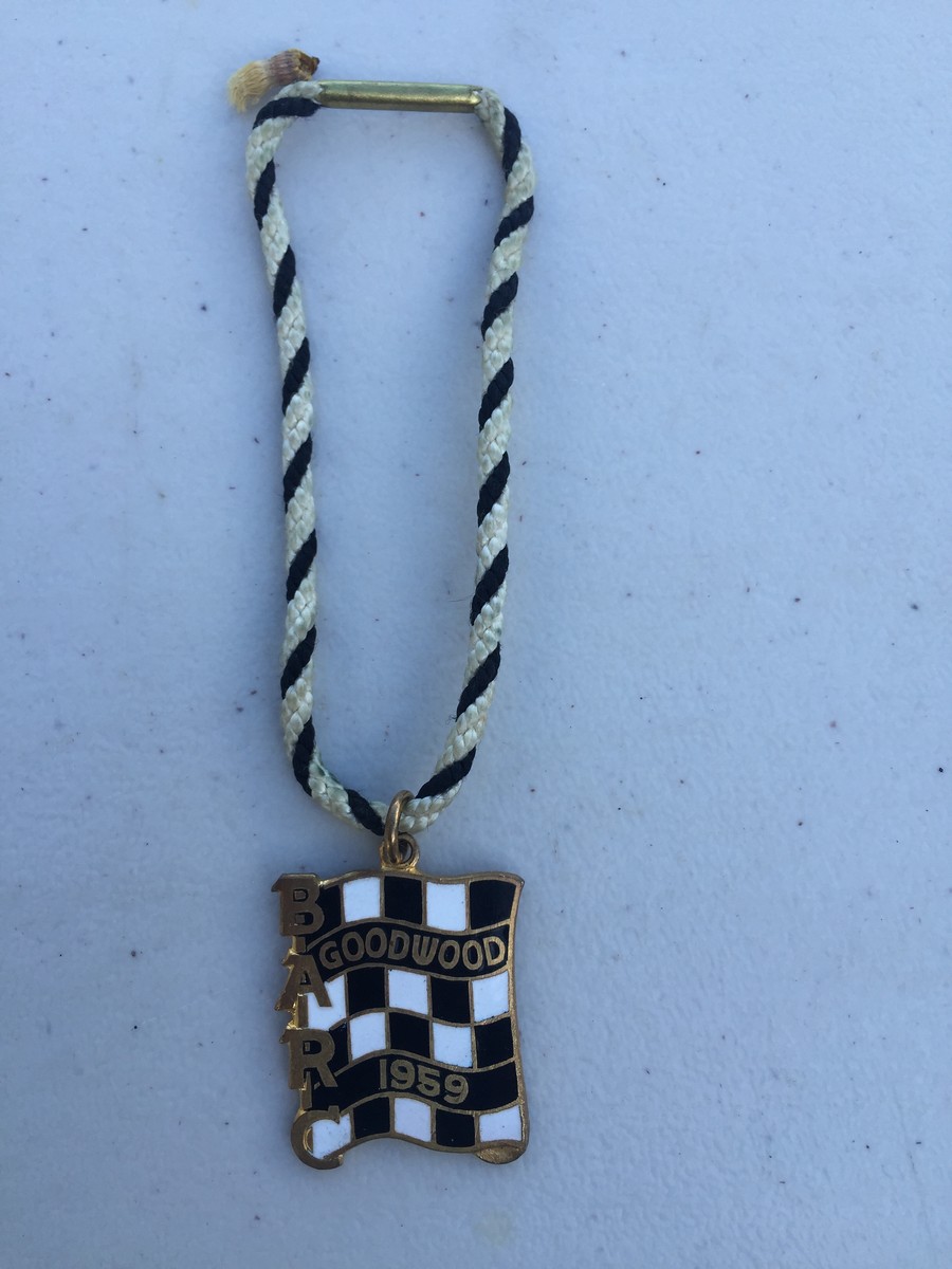 A BARC Goodwood black and white chequer enamel badge for 1959, with black and white string,