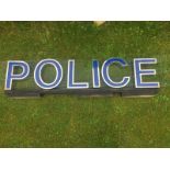 A group of metal letters forming the word 'Police', with blue perspex inserts, mounted for